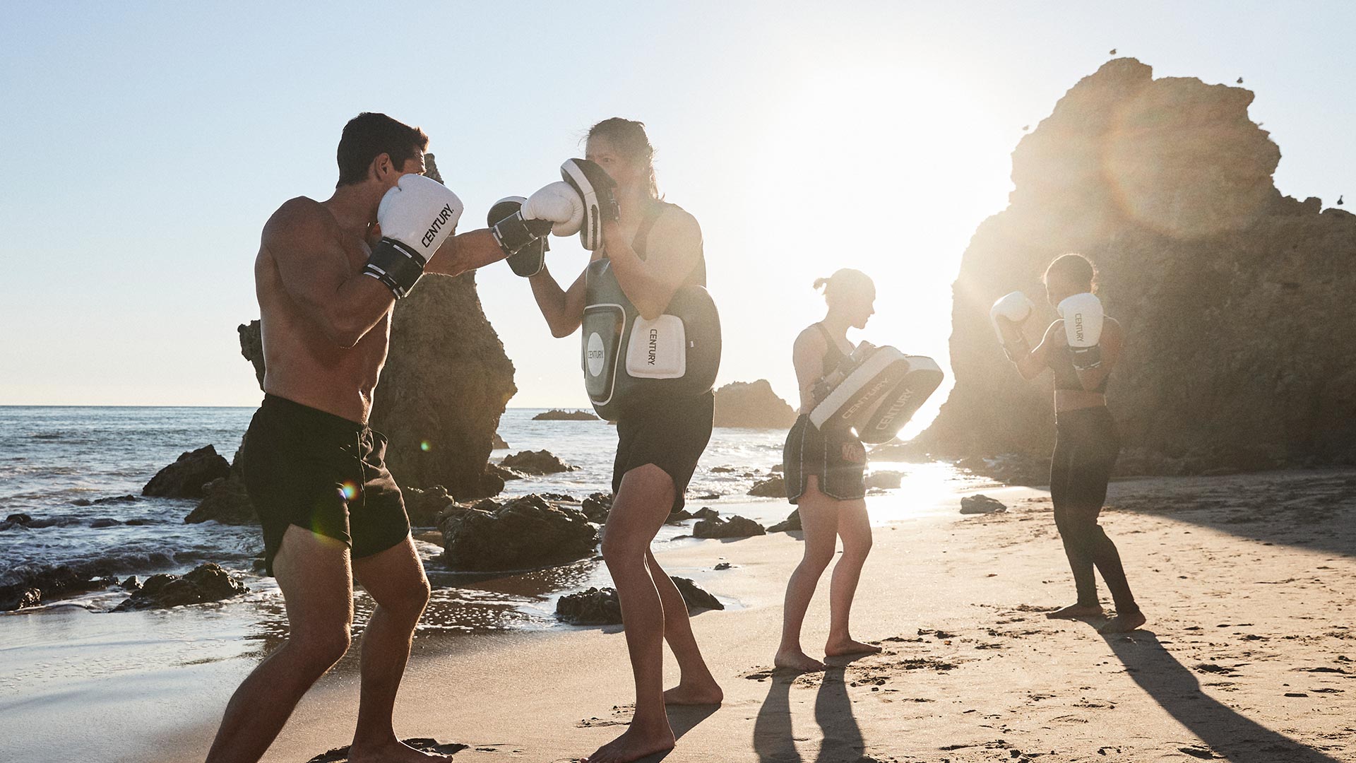 Athletes training pad work with Century Creed gear