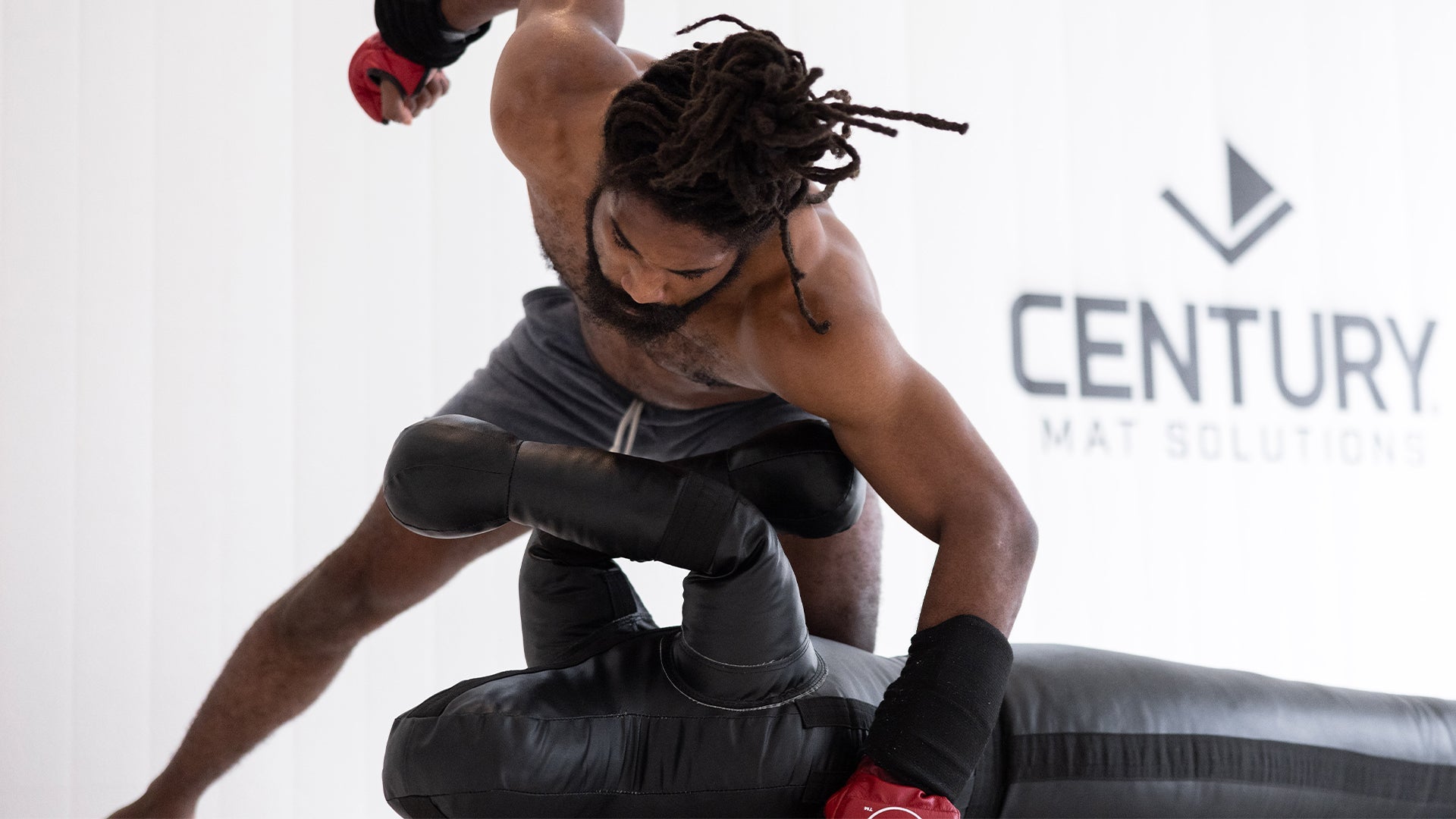 Athlete training ground and pound on a Century grappling dummy