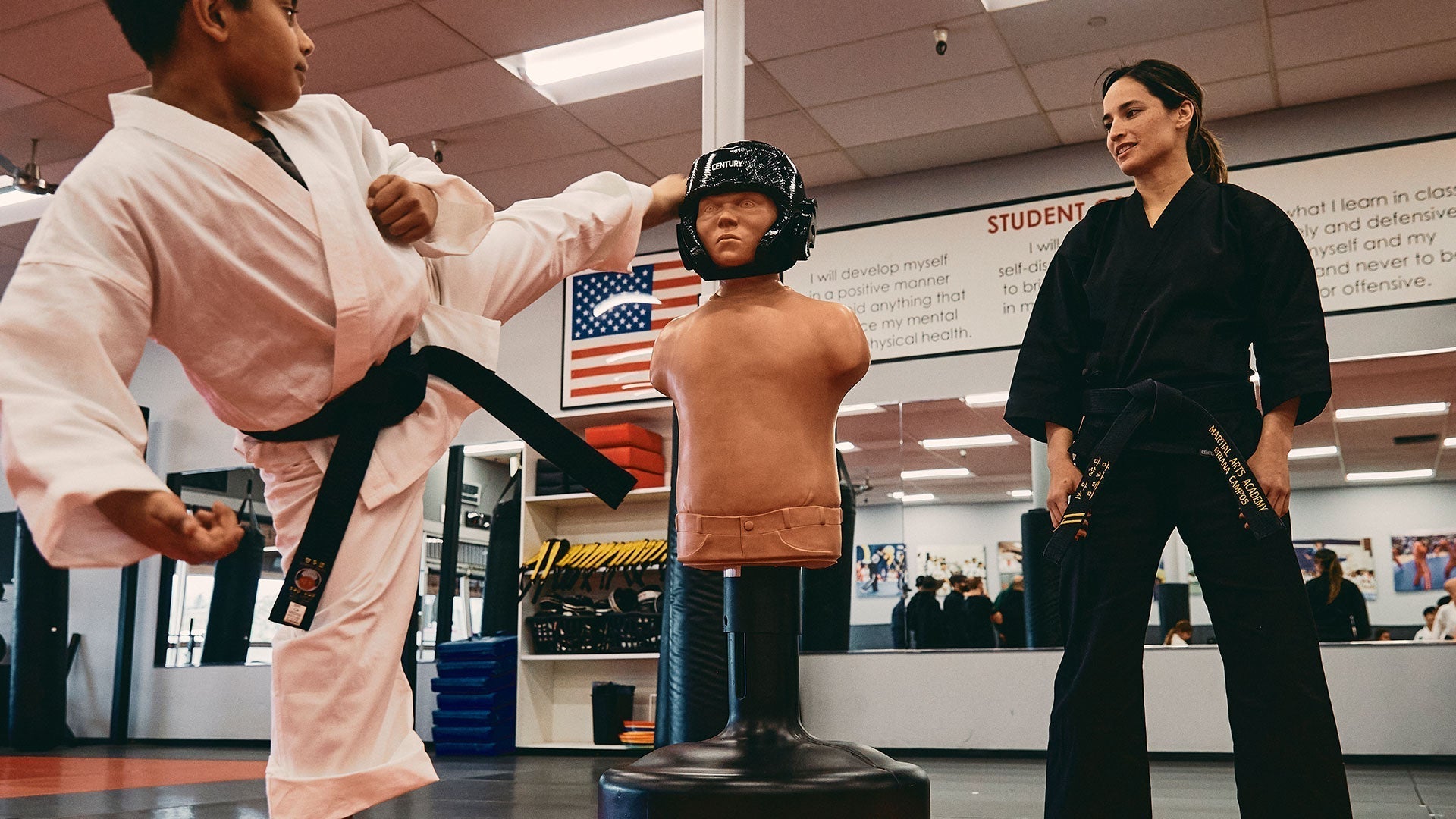 Youth Training Bags - Century Martial Arts, kid kicking bob in century uniform and belt