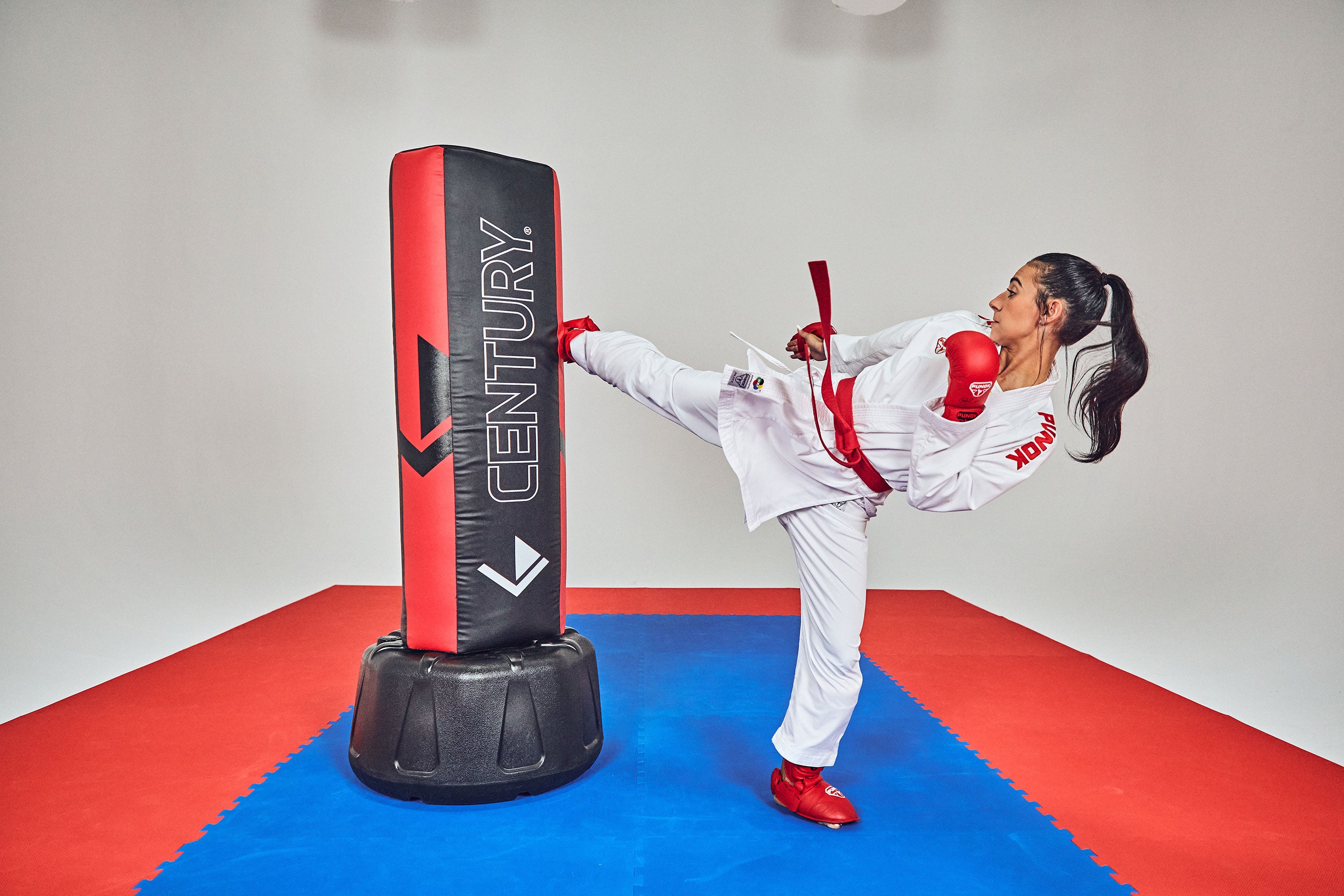 woman kicking freestanding training bag