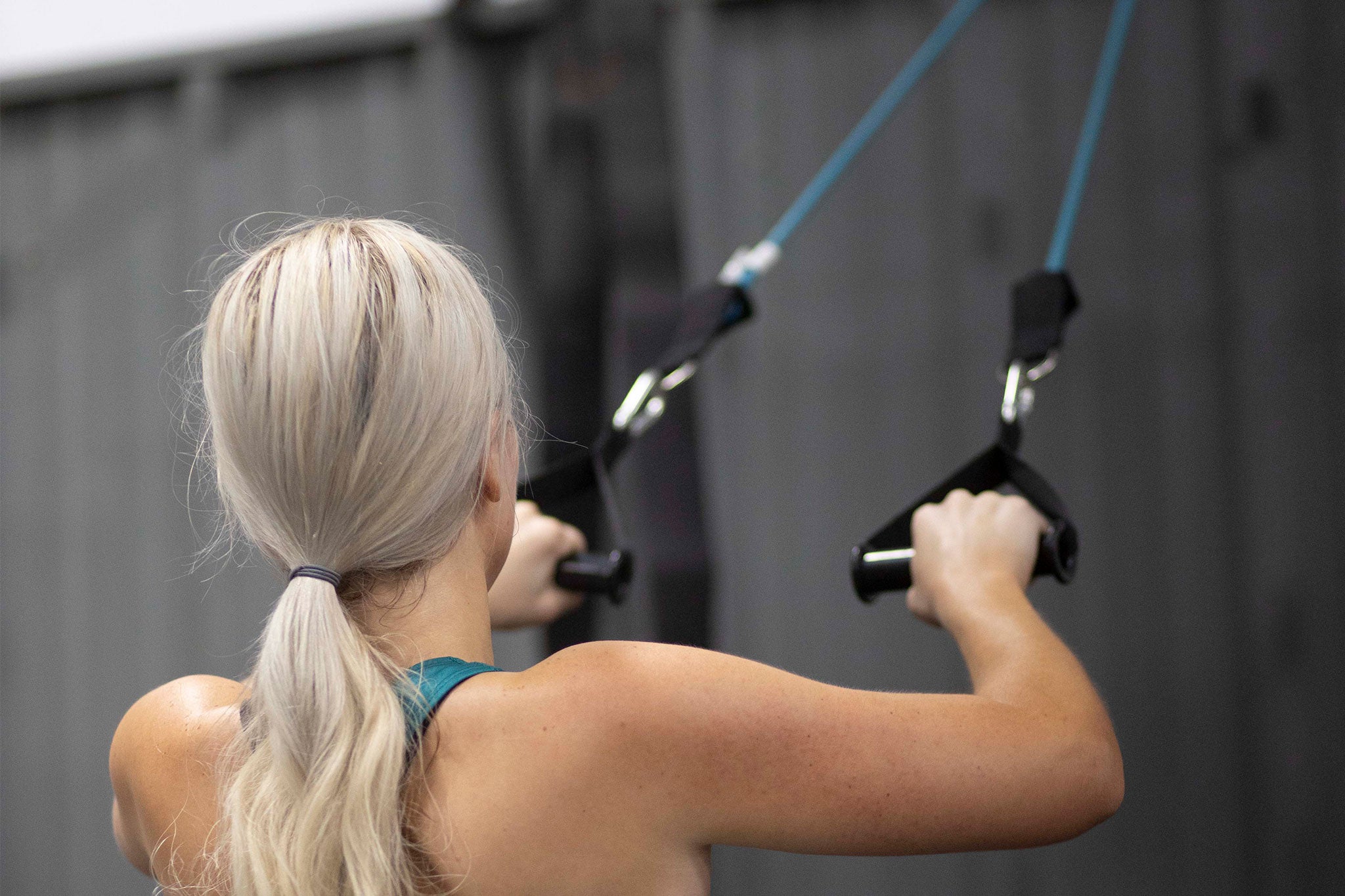 woman pulling blue resistance band
