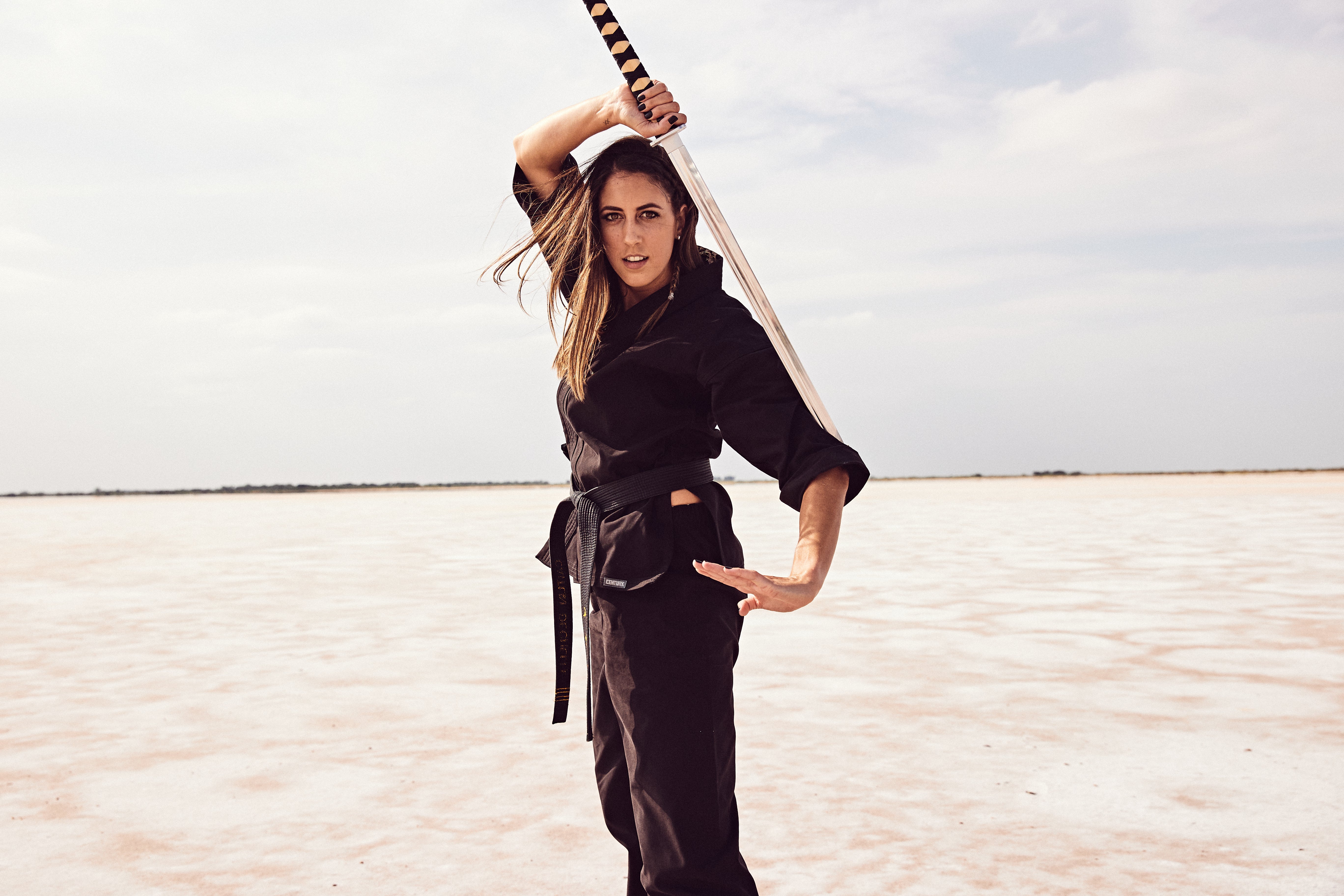 Caitlin Dechelle posing with sword on salt plains