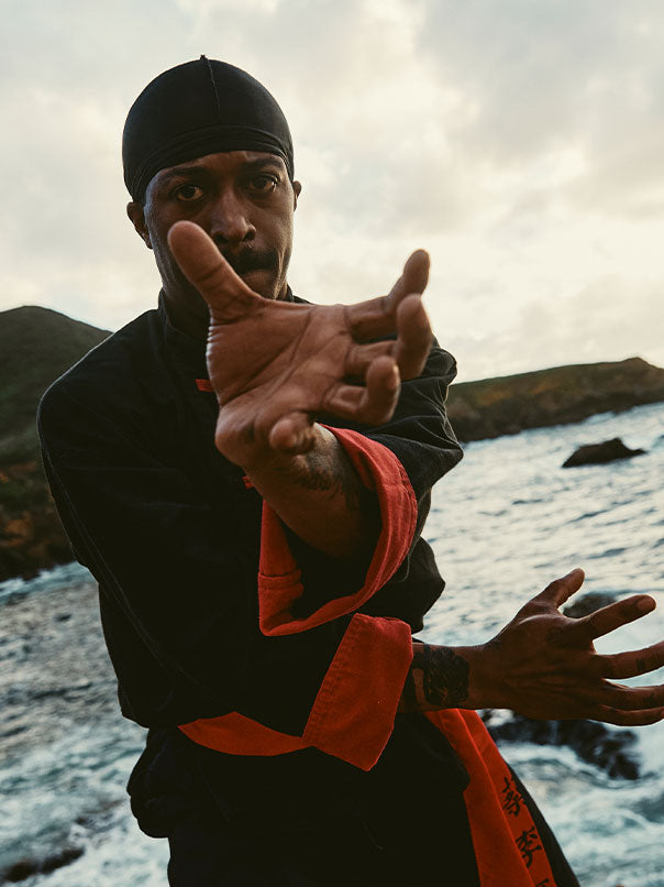 Rob Campbell training near ocean in Kung Fu uniform