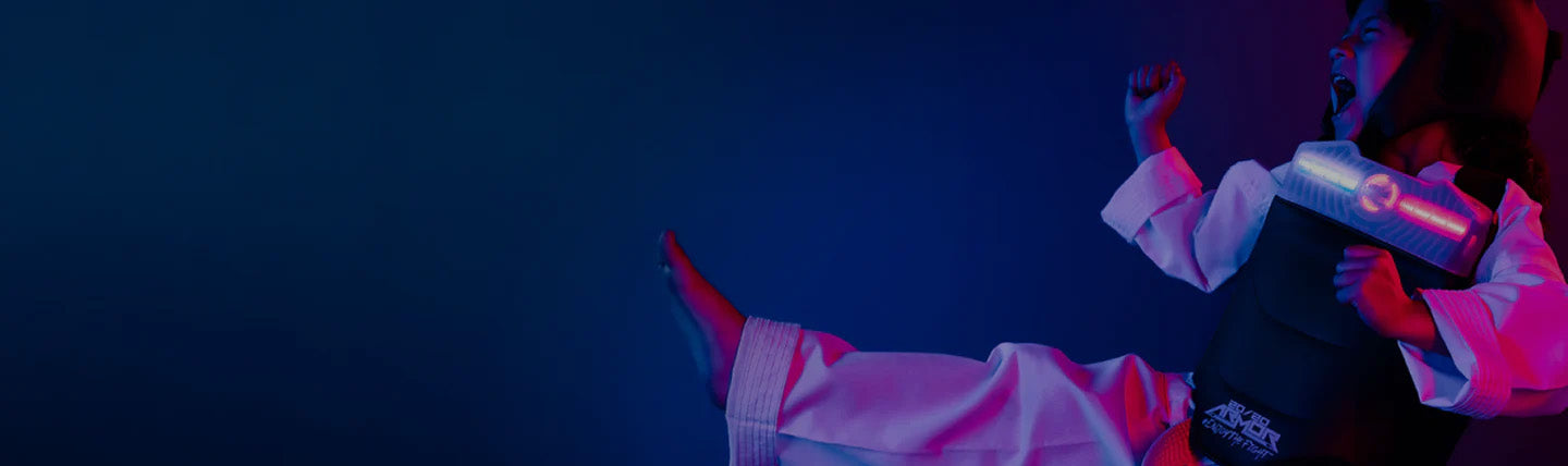 young martial artist kicking in blue and pink light