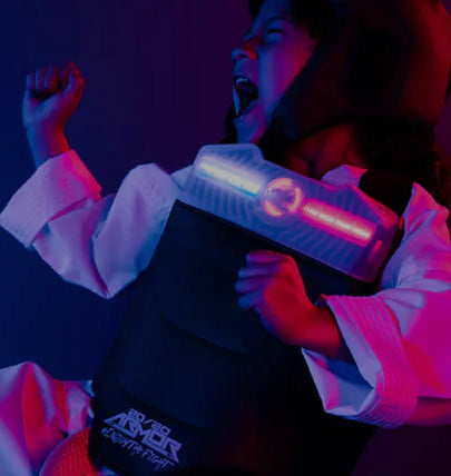 young martial artist kicking in blue and pink light